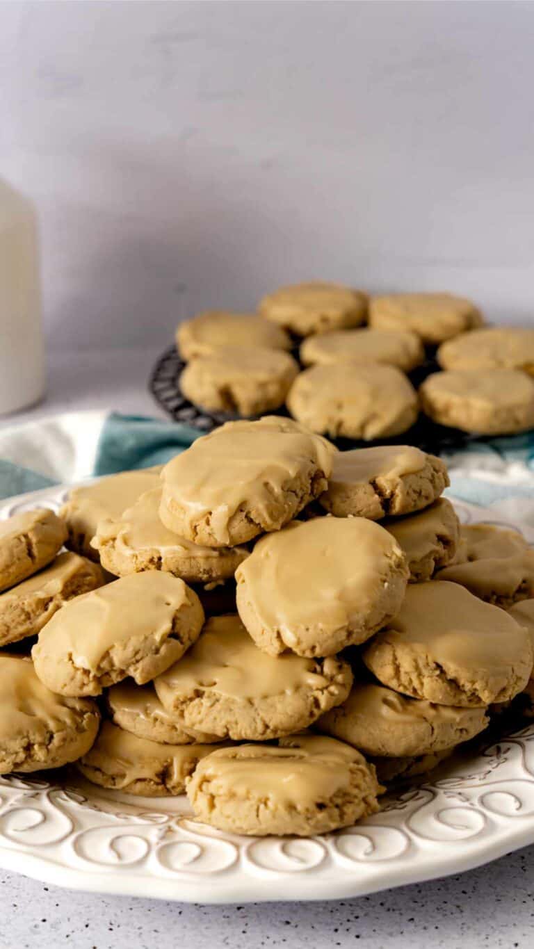 A plate of glazed maple brown sugar cookies with cookies in the background.