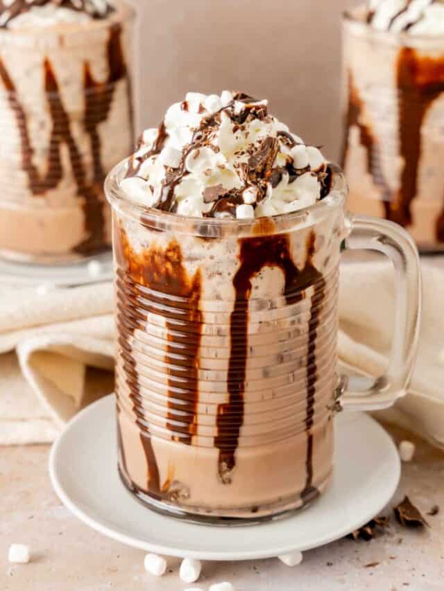 Once glass of frozen hot chocolate in front of two other glasses of frozen hot cocoa.