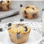 jumbo blueberry muffins glass of milk fresh blueberries gray background white plate white placemat