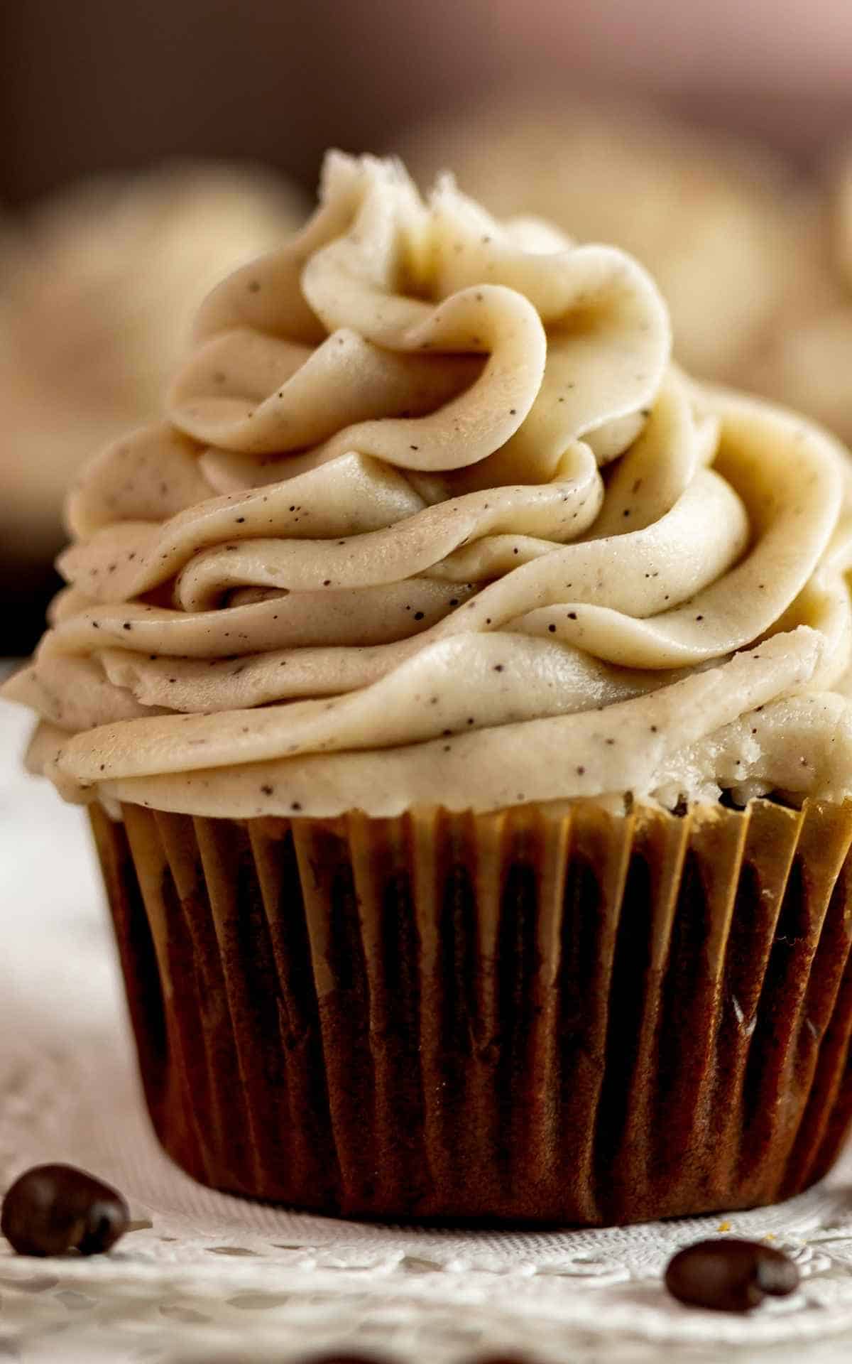 Chocolate cupcakes with espresso buttercream frosting on doily.