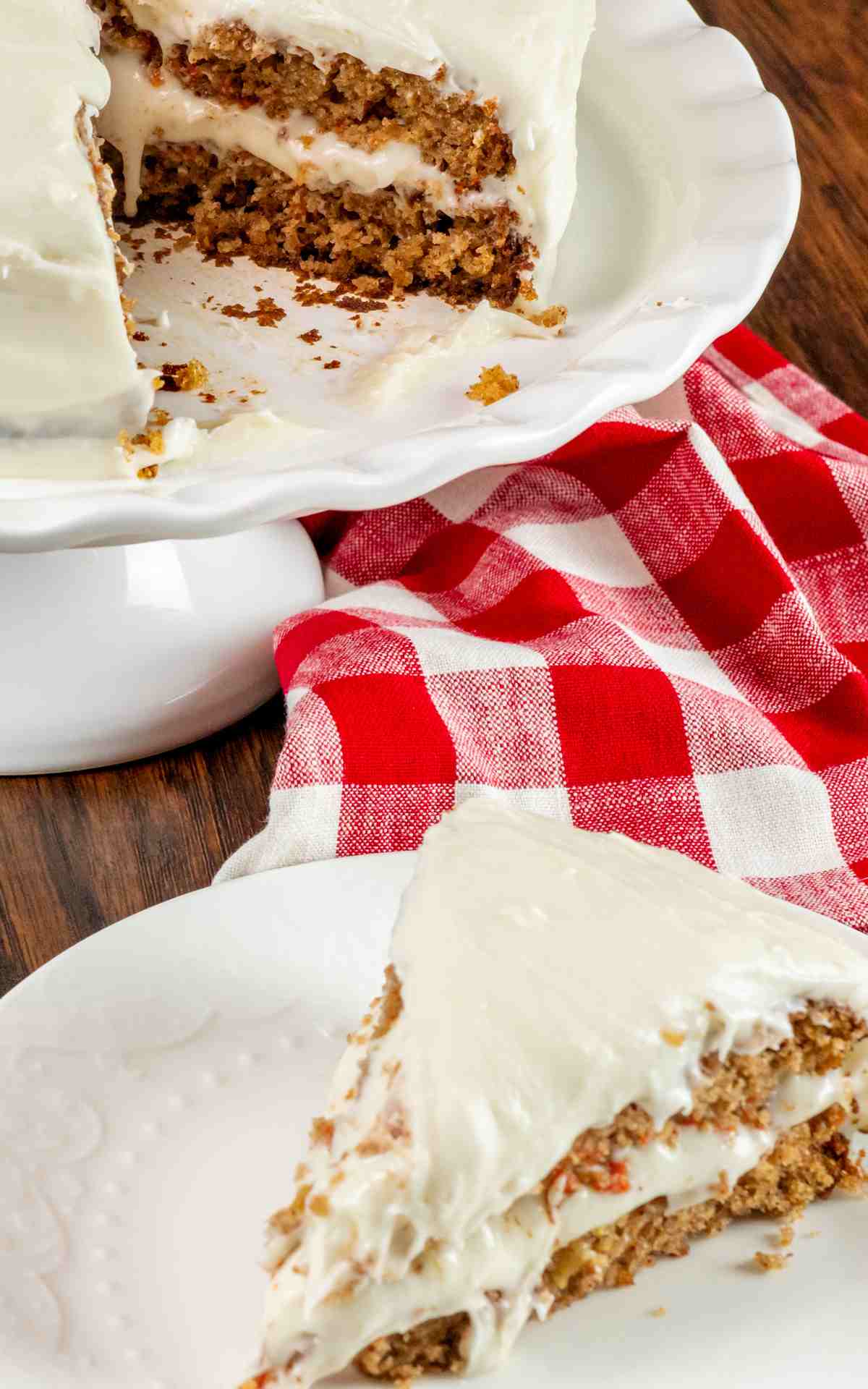 A slice taken out of a layered carrot cake with homemade icing.