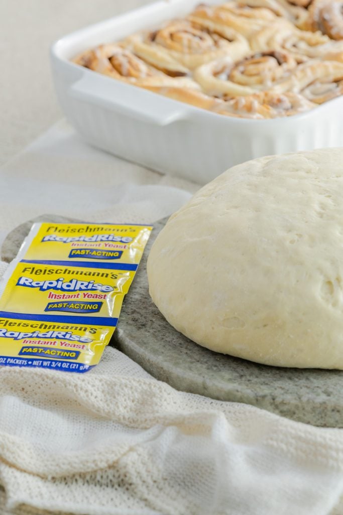 Proofed cinnamon roll dough on a stone paddle.