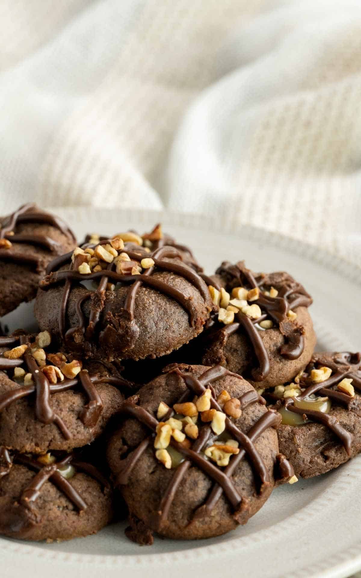 Side view of chocolate thumbprint cookies with salted caramel filling.