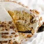 A slice of butter pecan cake being pulled from a decorated southern butter pecan cake.