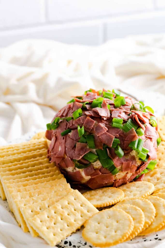 Dried Beef Cheese ball on a platter surrounded by crackers.