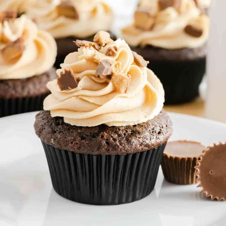 A chocolate cupcake topped with peanut butter buttercream frosting and chopped Reese's cups.