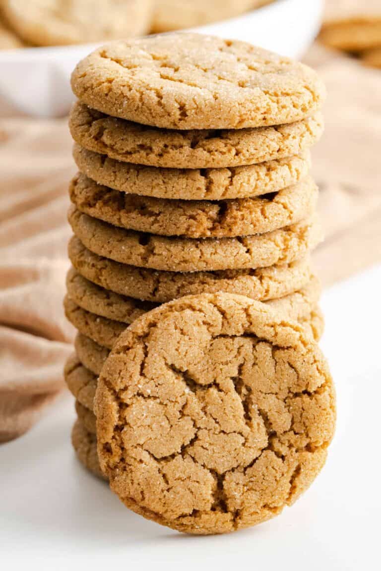 Stacked chewy gingersnap cookie rolled in granulated sugar with a cookie propped in front.