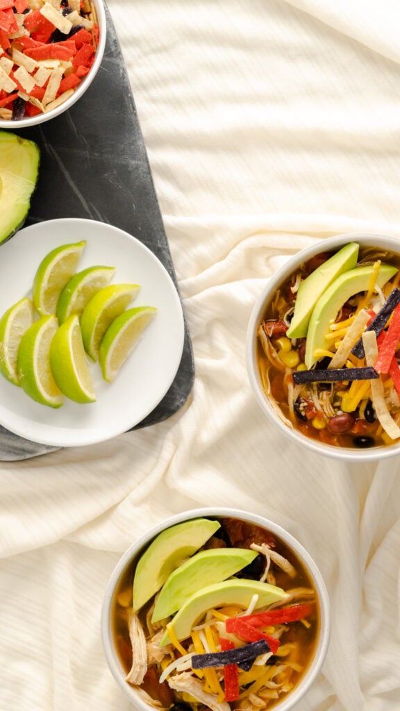 Chicken tortilla soup with garnishments on side.