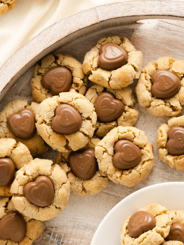 peanut butter blossom cookies with heart shaped chocolates on round serving tray