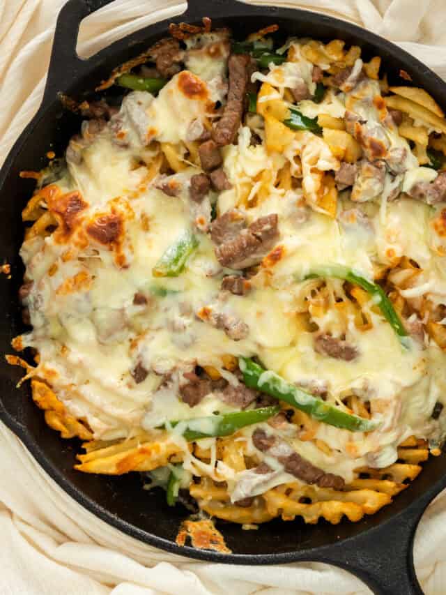 close up of Philly steak and cheese fries in cast iron skillet