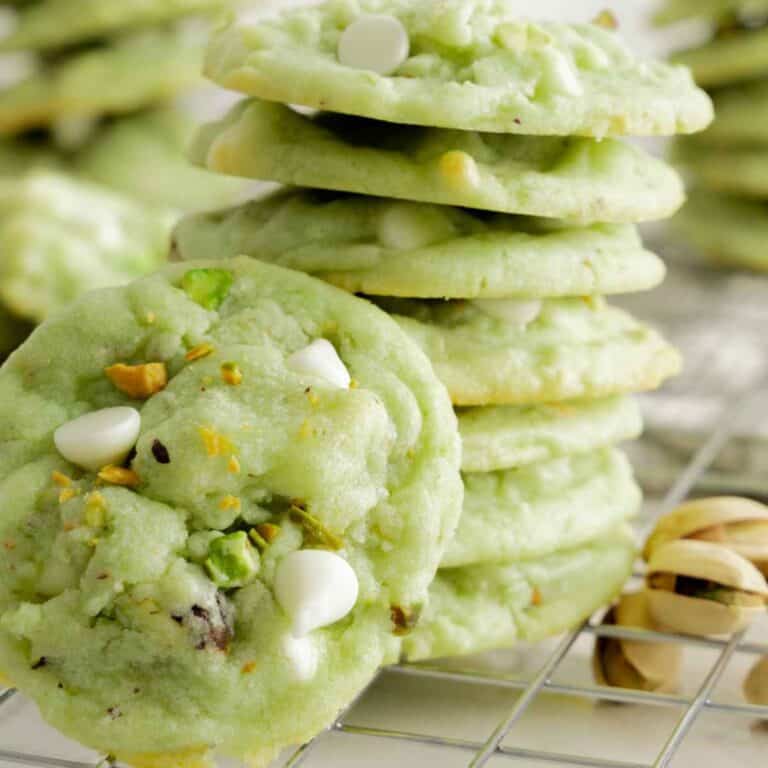 A stack of soft pistachio pudding cookies with white chocolate chips.