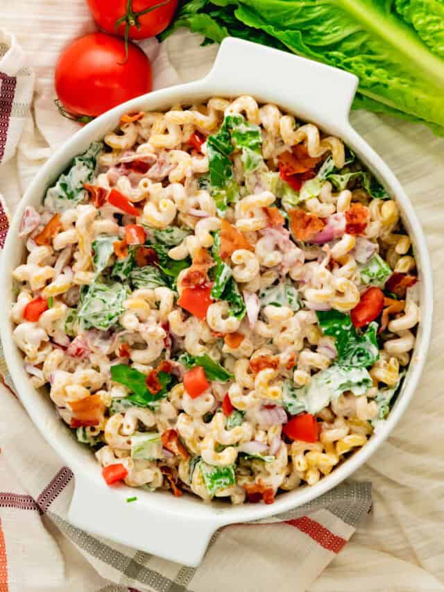 Top view of BLT pasta salad made with cavatappi pasta in white casserole dish.