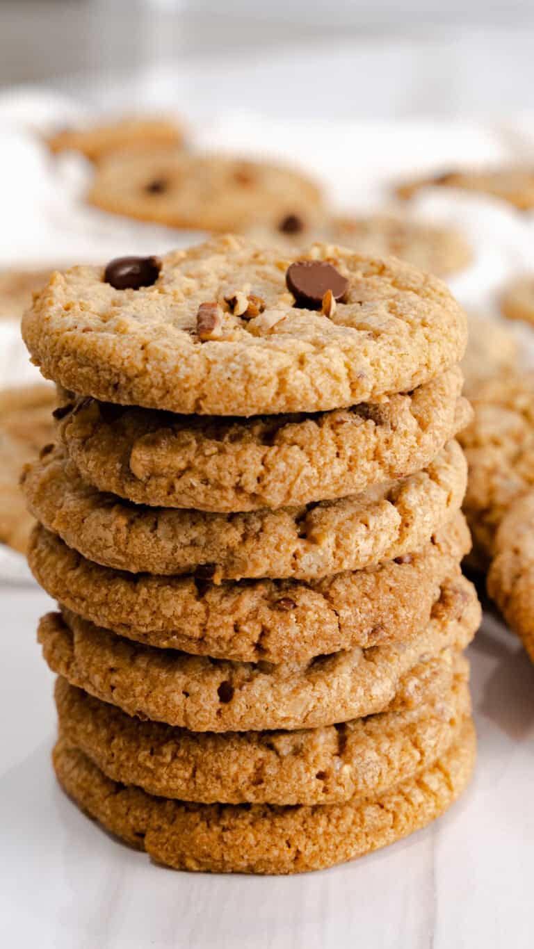 A stack of pecan cookies topped with chocolate chips.