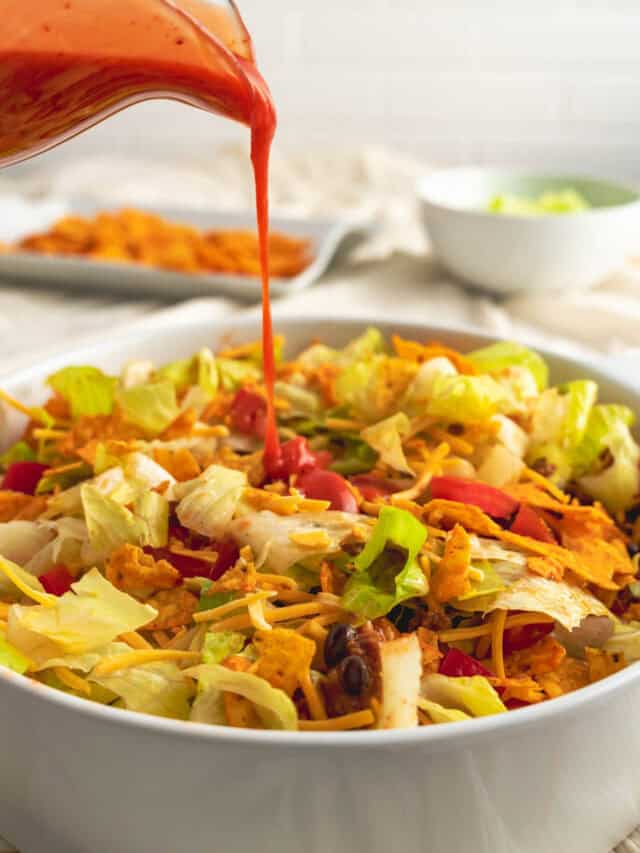 Catalina dressing being drizzled on Dorito taco salad.