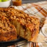 A slice of caramel apple coffee cake pulled away from a platter.