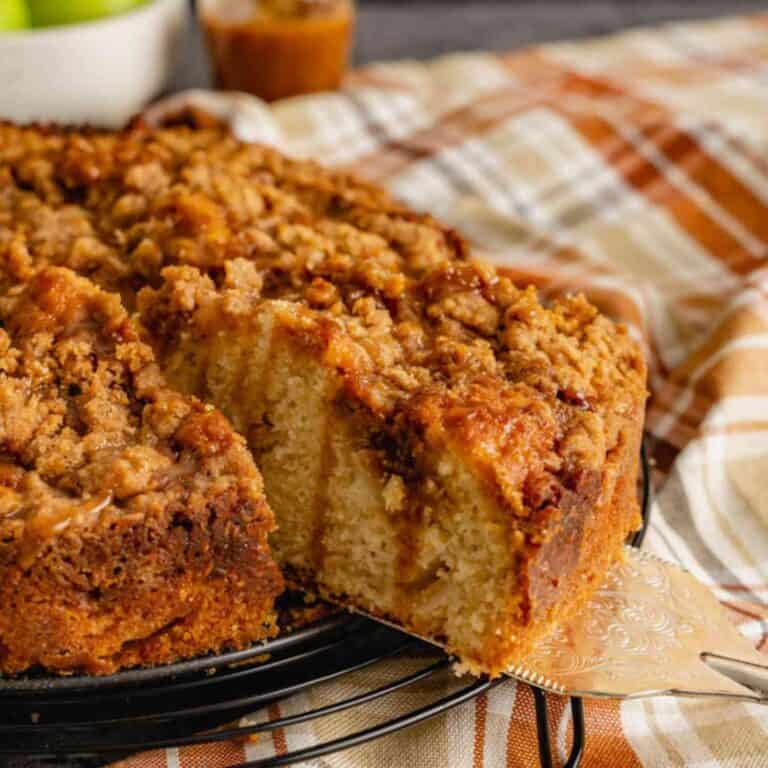 A slice of caramel apple coffee cake pulled away from a platter.
