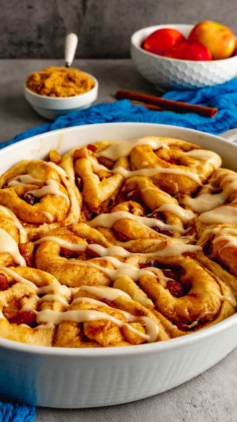 A 9 inch oval baking dish with apple cider cinnamon rolls.