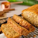 Sliced banana zucchini bread on a square black cooling rack.