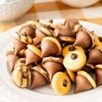 A plate of acorn kisses made with nilla wafers, fudge stripes, mini chocolate chips, and hershey kisses.