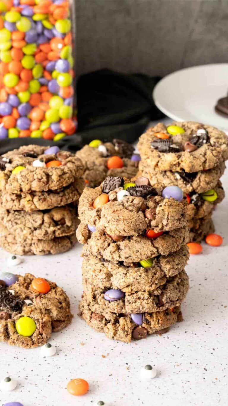 Oreo Halloween Cookies in three stacks with Ghoul's Mix M&M's in the background.