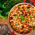 Instant Pot Pasta e Fagioli in a red pot garnished with fresh parsley.