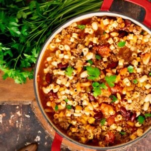 Instant Pot Pasta e Fagioli in a red pot garnished with fresh parsley.