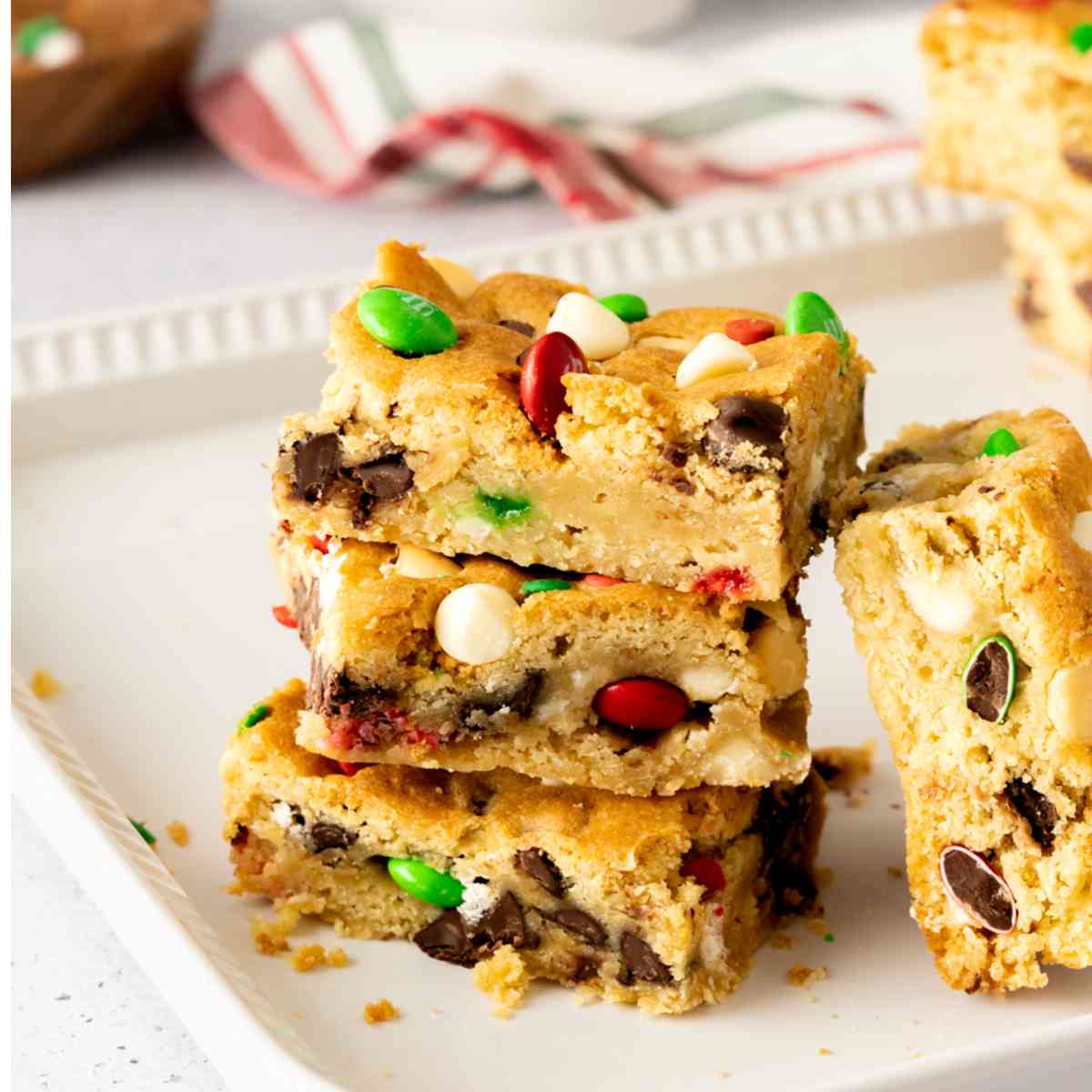 Three Christmas Sugar Cookie Bars stacked on a plate.