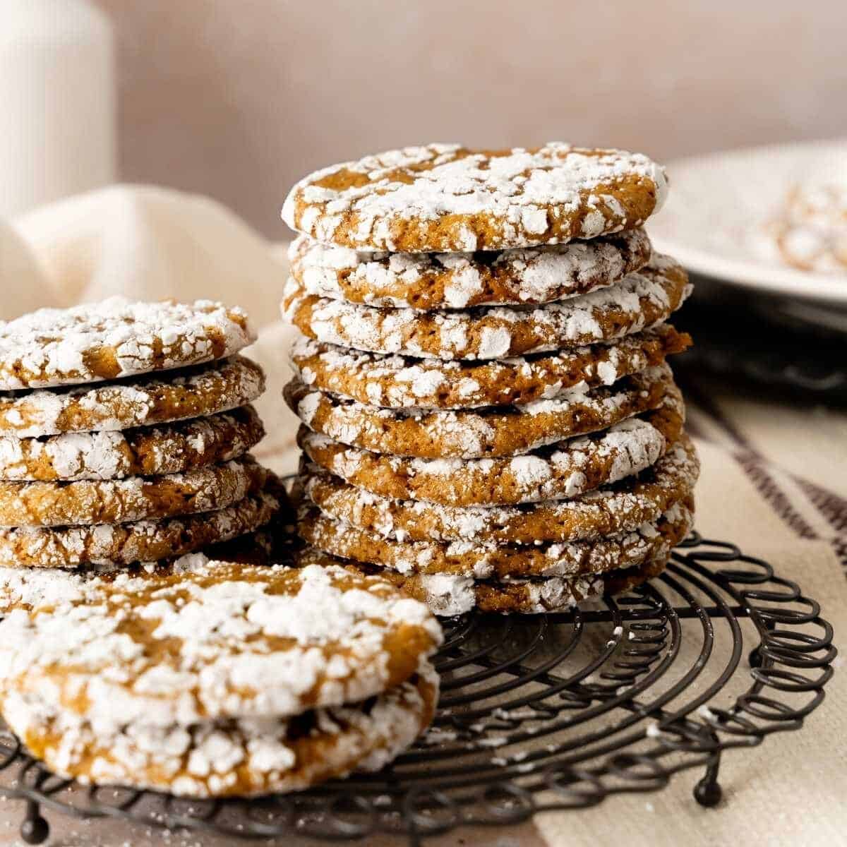 Stacks of crinkle gingerbread cookies on a decorated round wire rack.