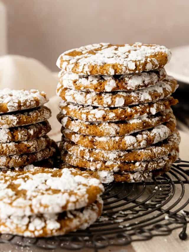 Stacks of crinkle gingerbread cookies on a decorated round wire rack.