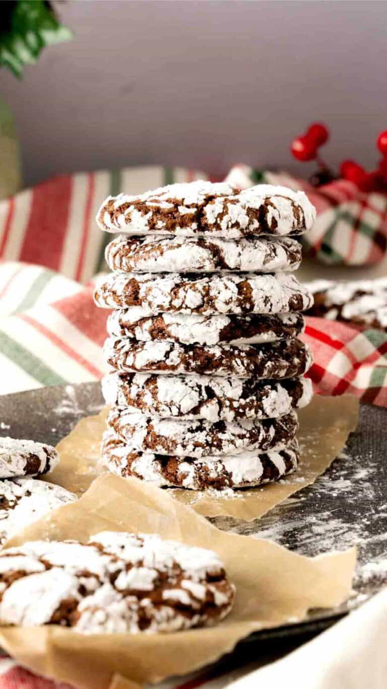 A stack of hot cocoa crinkle cookies with a Christmas background.