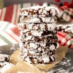 A stack of hot cocoa crinkle cookies with a Christmas background.