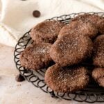 A wire cooling rack with stacked chocolate sugar cookies.