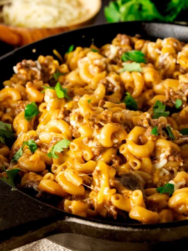 Instant Pot Sloppy Joe Mac and Cheese served in a cast iron skillet with melted cheese,.