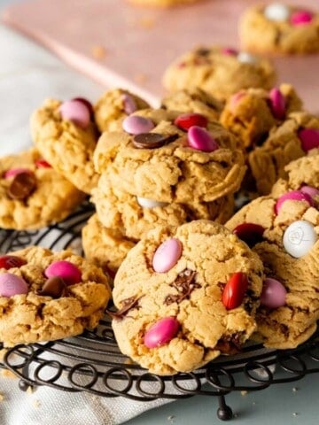 Peanut Butter M&M Cookies stacked on a decorative round rack with Valentine's day M&M's.