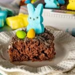 A slice of Easter Pudding Poke on a decorative plate with a blue bunny peep.