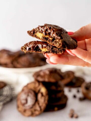 A buckeye cookie topped with chocolate broken in half to show the peanut butter filling.