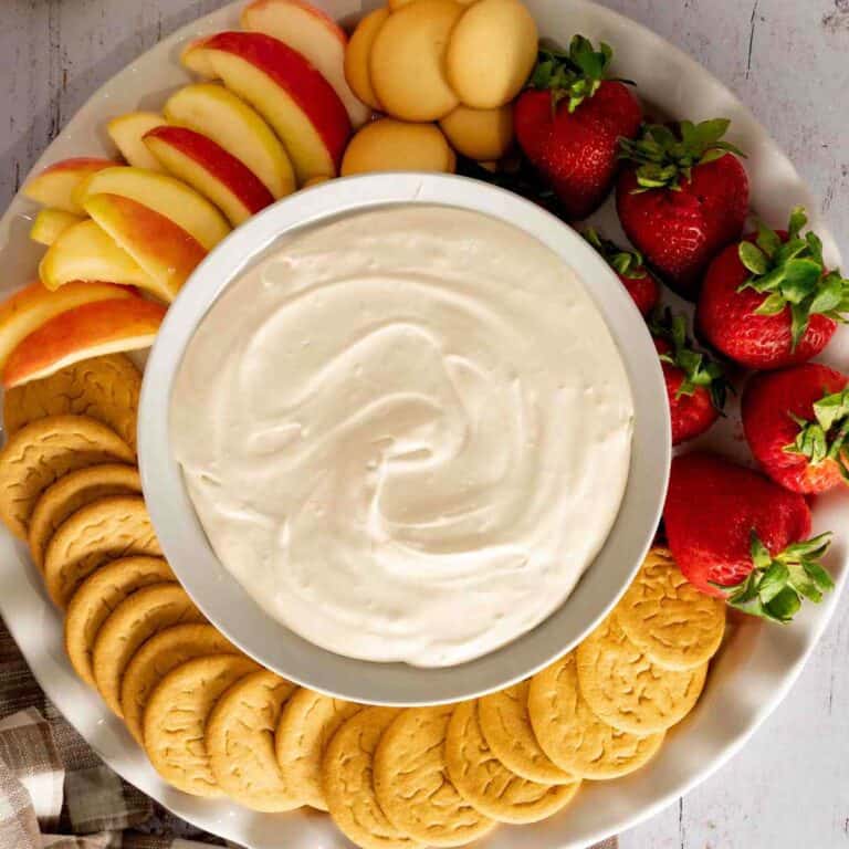 Brown Sugar Fruit Dip in a bowl with a spread of apples, strawberries, and gingersnap cookies.