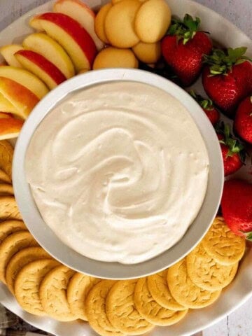 Brown Sugar Fruit Dip in a bowl with a spread of apples, strawberries, and gingersnap cookies.