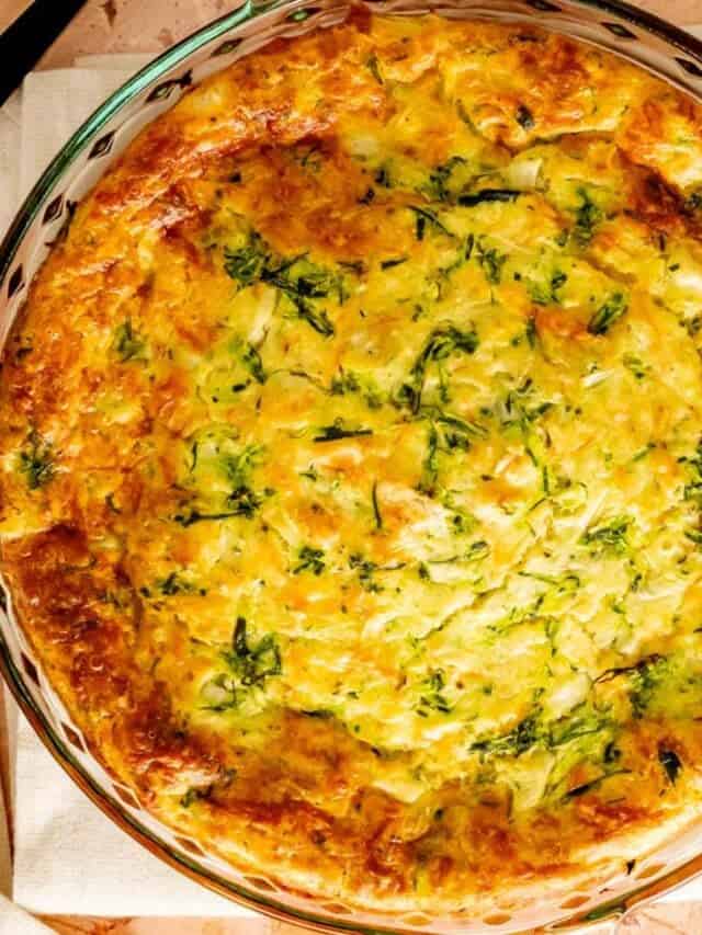 Bisquick Zucchini Quiche in a glass pie plate with a serving utensil.