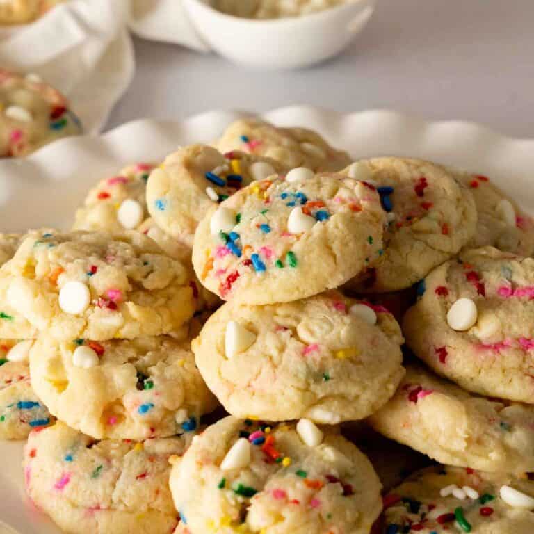 A white scalloped platter stacked with confetti cookies.