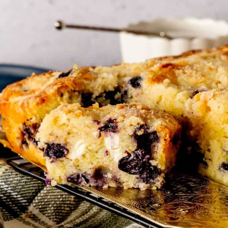 Blueberry Cream Cheese Coffee Cake cut into squares and served with a cake server.