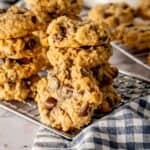 Peanut butter oatmeal chocolate chip cookies stacked on a cooling rack.