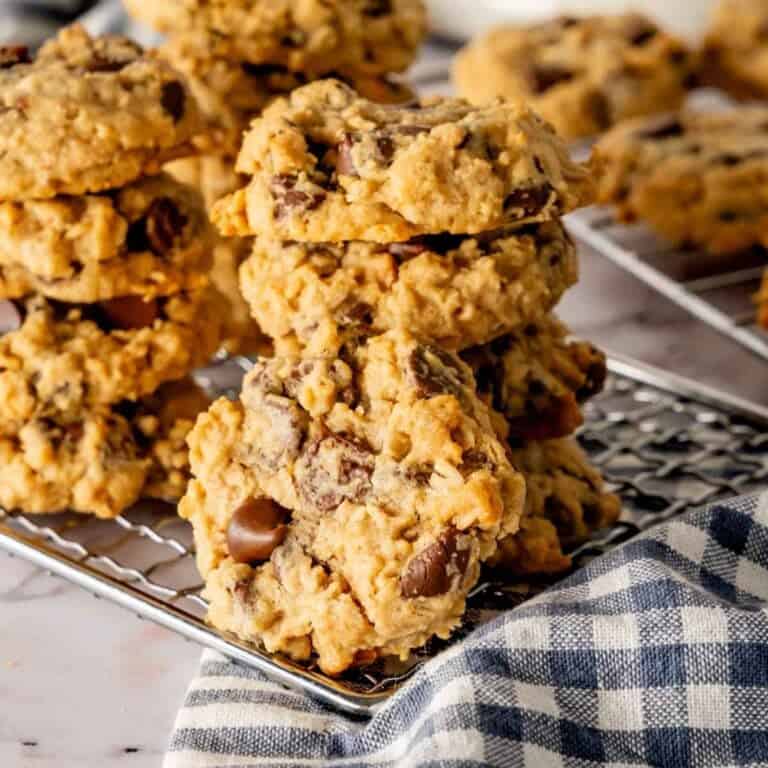 Peanut butter oatmeal chocolate chip cookies stacked on a cooling rack.