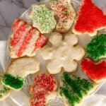 Birds eye view of cream cheese sugar cookies for Christmas on decorative plate.