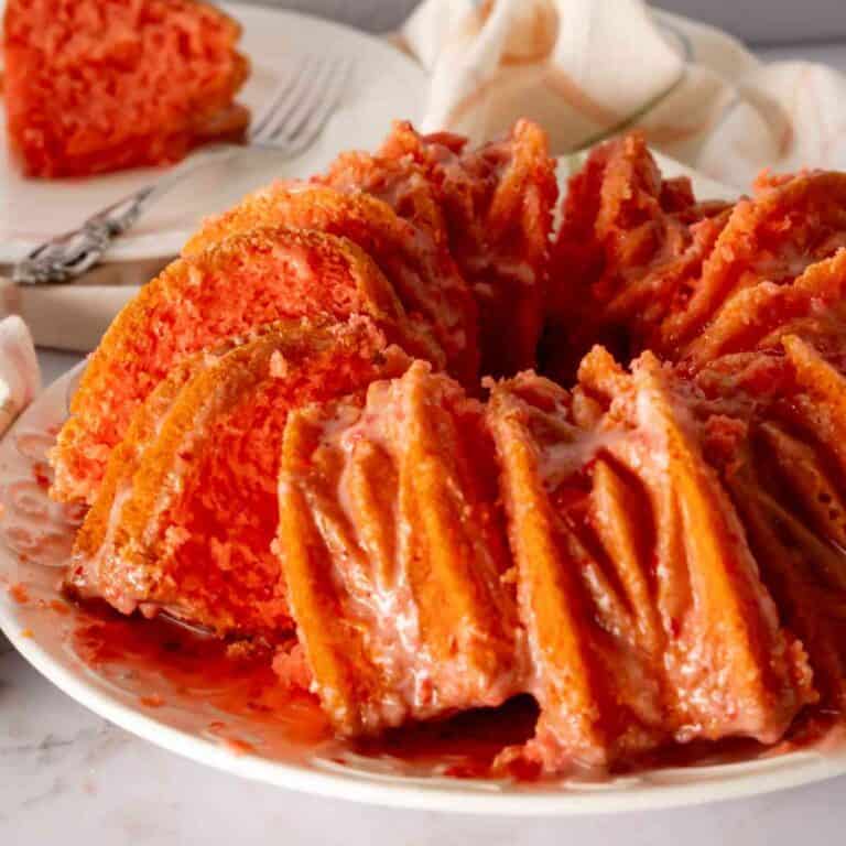 Strawberry Bundt Cake cut into slices on a decorative plate.