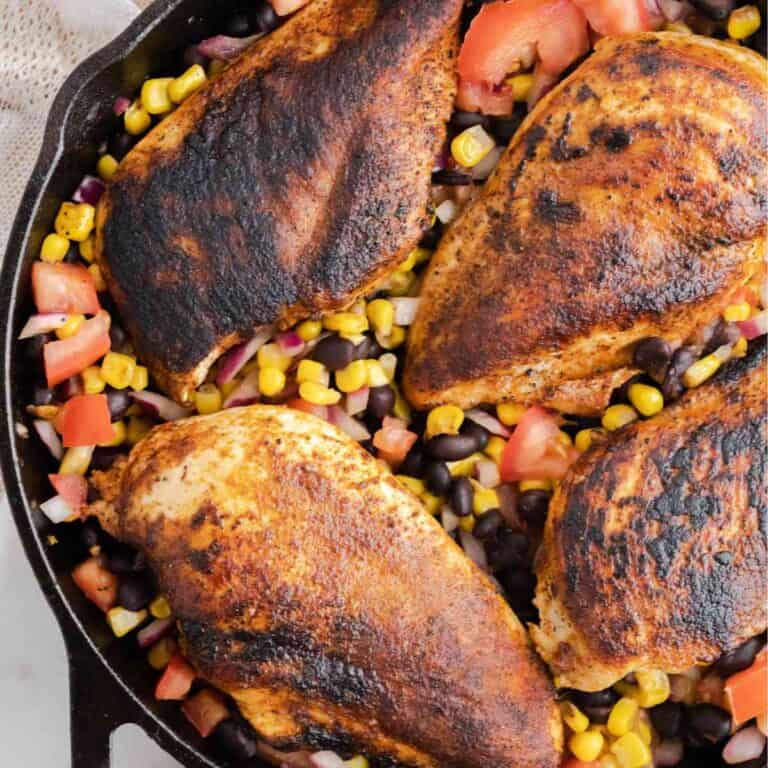Cowboy Caviar with blackened chicken breasts in a cast iron skillet.
