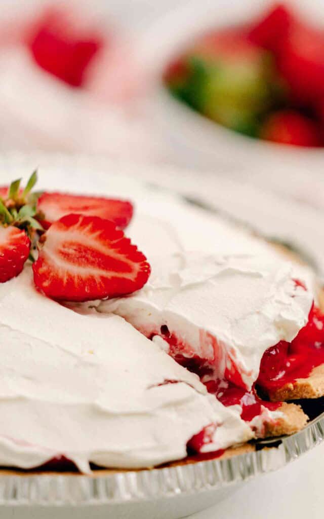 Side view of a strawberry cream cheese pie that has been cut into.