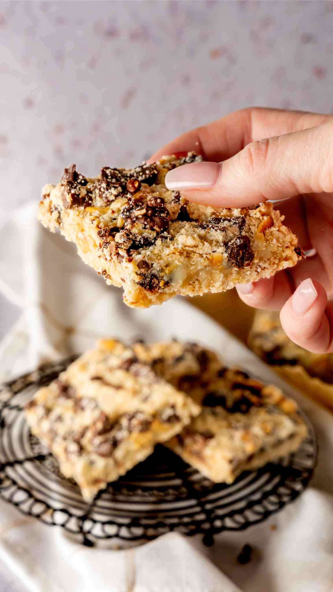 A chocolate oat bar in a manicured hand.
