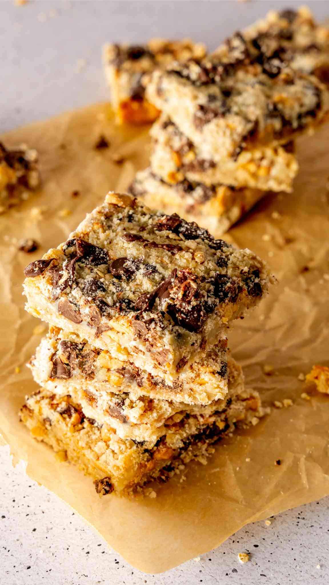 A stack of oat and chocolate bars on parchment paper.