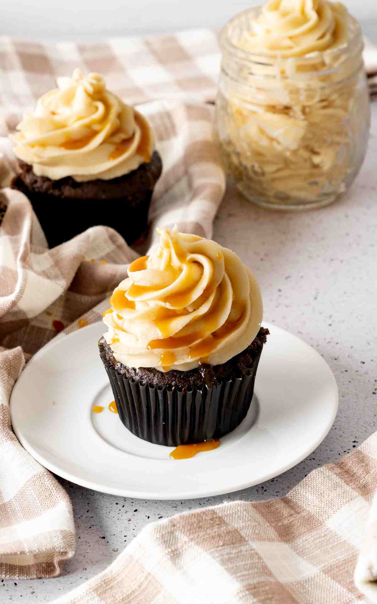 A chocolate cupcake topped with salted caramel frosting and drizzled with salted caramel.